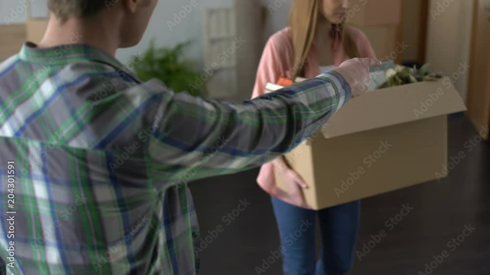 Angry man breaking up with girlfriend, unhappy woman leaving house, stuff in box Angry man breaking up with girlfriend, unhappy woman leaving house, stuff in box