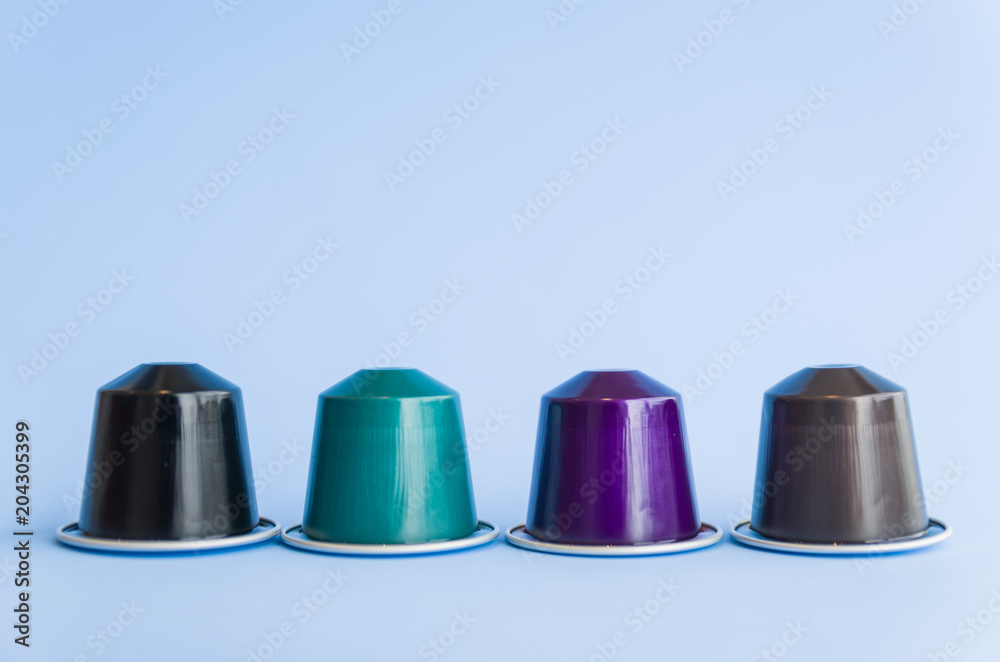 Beautiful colored coffee capsules on light blue background. Beautiful colored coffee capsules on light blue background.
