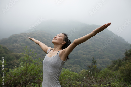 Woman breathing fresh air on morning mountain valley