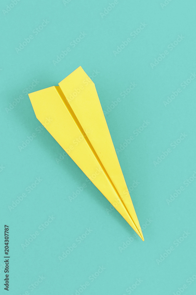 Flat lay yellow paper plane on pastel blue background. Top view creative travel background concept - obrazy, fototapety, plakaty 