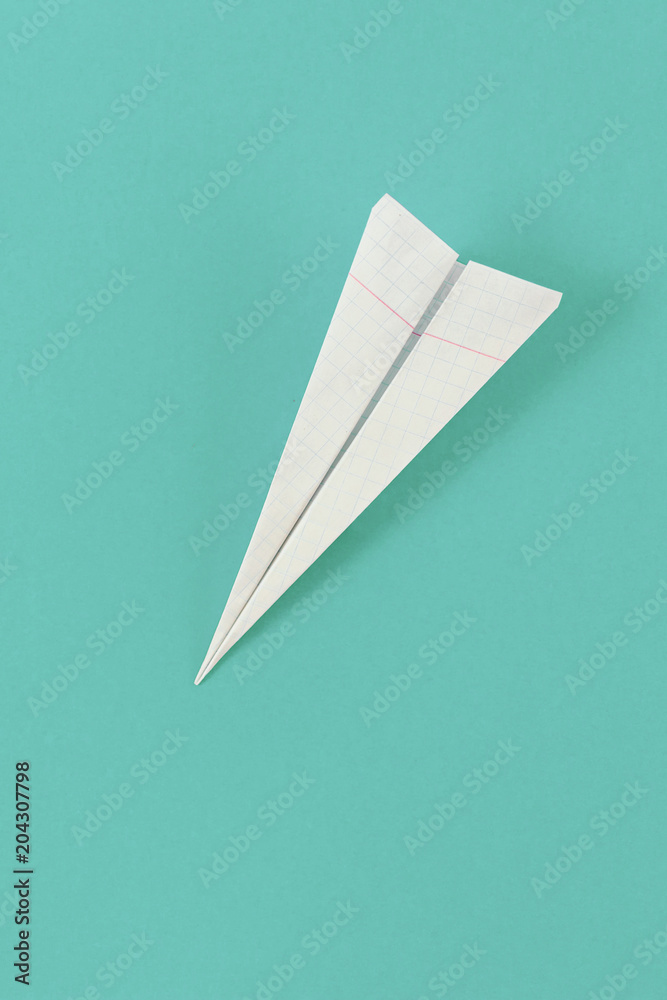Flat lay white paper plane cell on pastel background top view