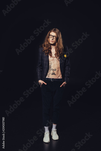 elegant tattooed man with long hair, isolated on black