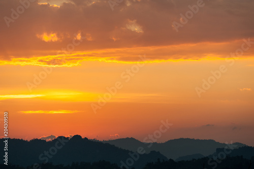 colorful dramatic sky with cloud at sunset. over silhouette mountains © fototrips