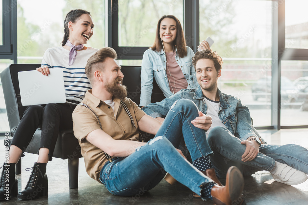 Successful business people sitting and resting together in modern light office Successful business people sitting and resting together in modern light office