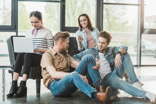 Successful business people resting and using gadgets in modern light office