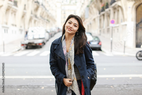 Chinese gladden girl standing in street background, walking after classes. Concept of international students and strolling in city. photo