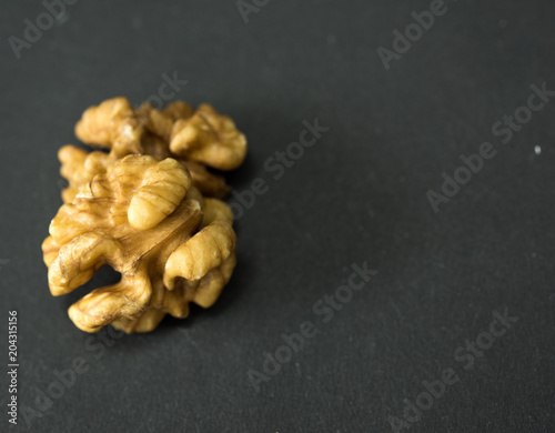 walnut, peeled two halves of the nut lies on a black background. macro shooting