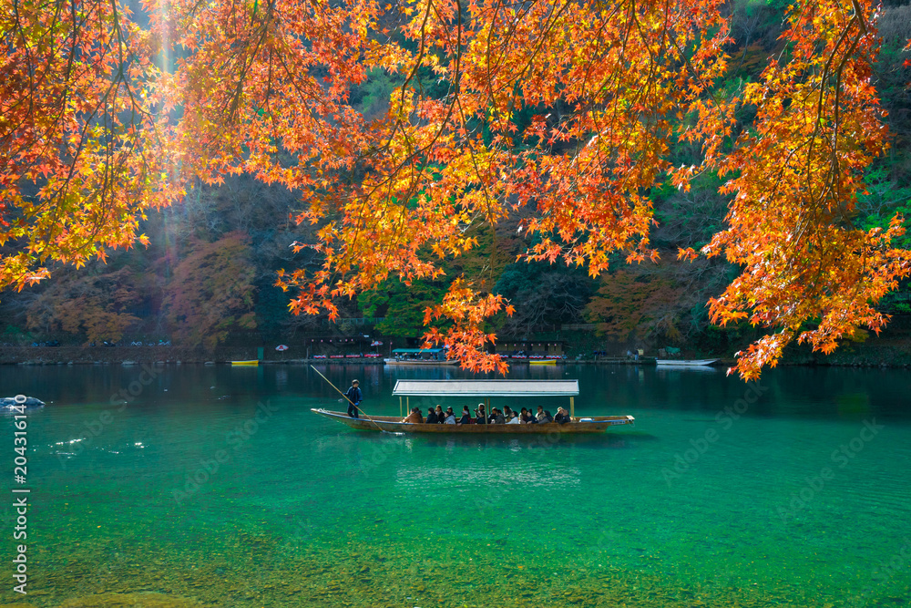 Obraz premium Pleasure boat at Arashiyama in Autumn season.