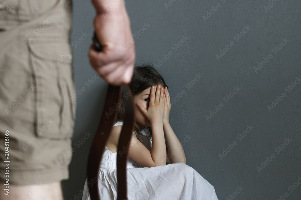 A man with a belt in his hand is going to punish a little girl