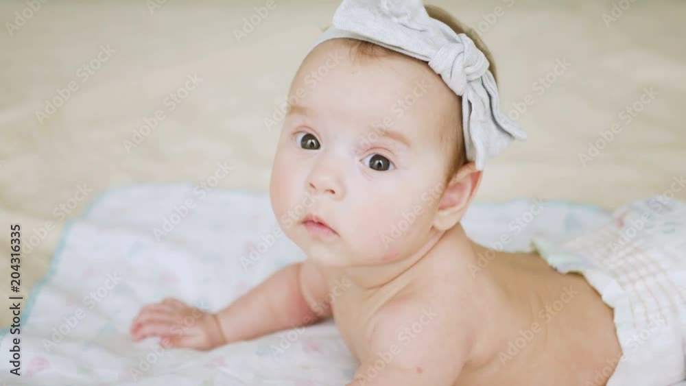 girl in a diaper without clothes lies on a large bed girl in a diaper without clothes lies on a large bed