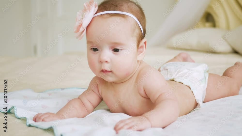 girl in a diaper without clothes lies on a large bed girl in a diaper without clothes lies on a large bed