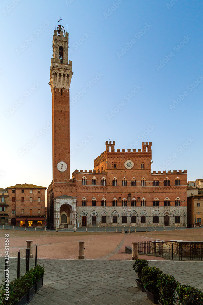 Central square of Siena - Piazza del Campo and the palace Palazzo Pubblico with tower Torre del Mangia in Siena, Tuscany, Italy.