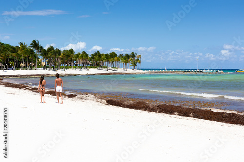 Woman and man walking by the beach on the Caribbean Sea