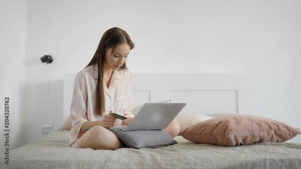 Beautiful woman is shopping online on her laptop indoor on bed. Beautiful woman is shopping online on her laptop indoor on bed.