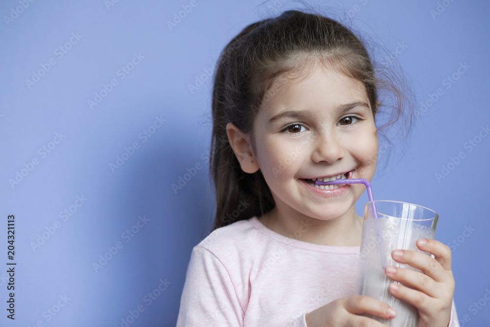 Happy little girl drinking a milk cocktail Happy little girl drinking a milk cocktail