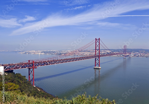 Ponte 25 de Abril Bridge in Lisbon, Portugal. Connects the cities of Lisbon and Almada crossing the Tagus River. View from Almada with Lisbon across the river.