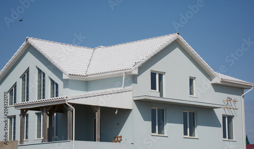 Modern house building with white tiled roof.