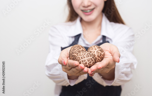 Young woman holding shiitake mushroom.