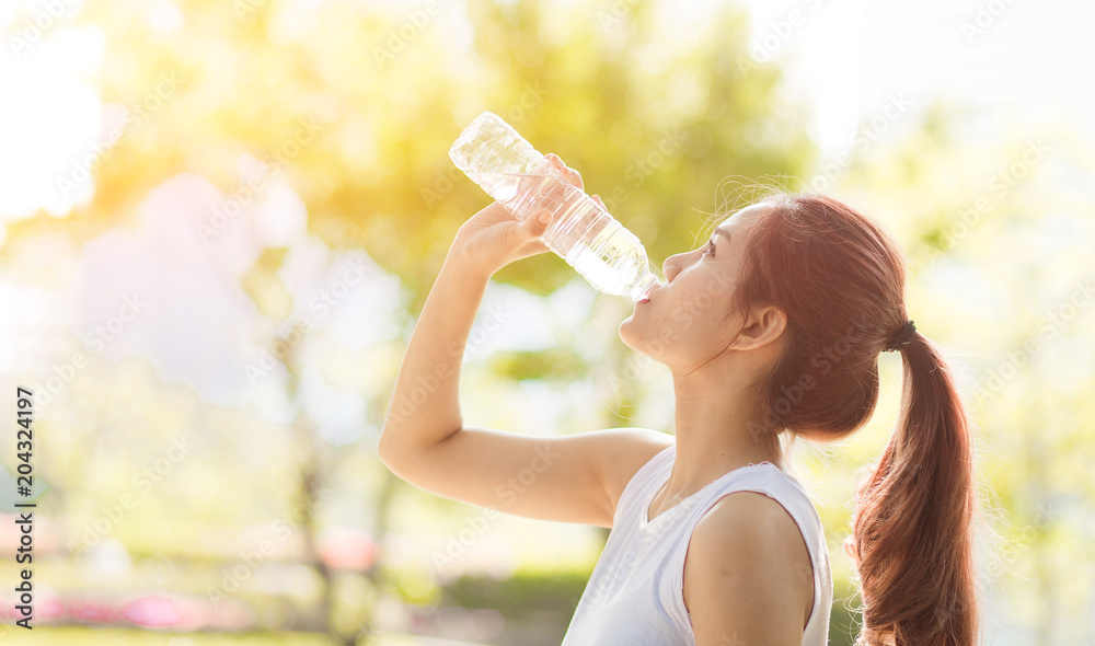 Young beautiful woman drinking water at summer green park. Young beautiful woman drinking water at summer green park.