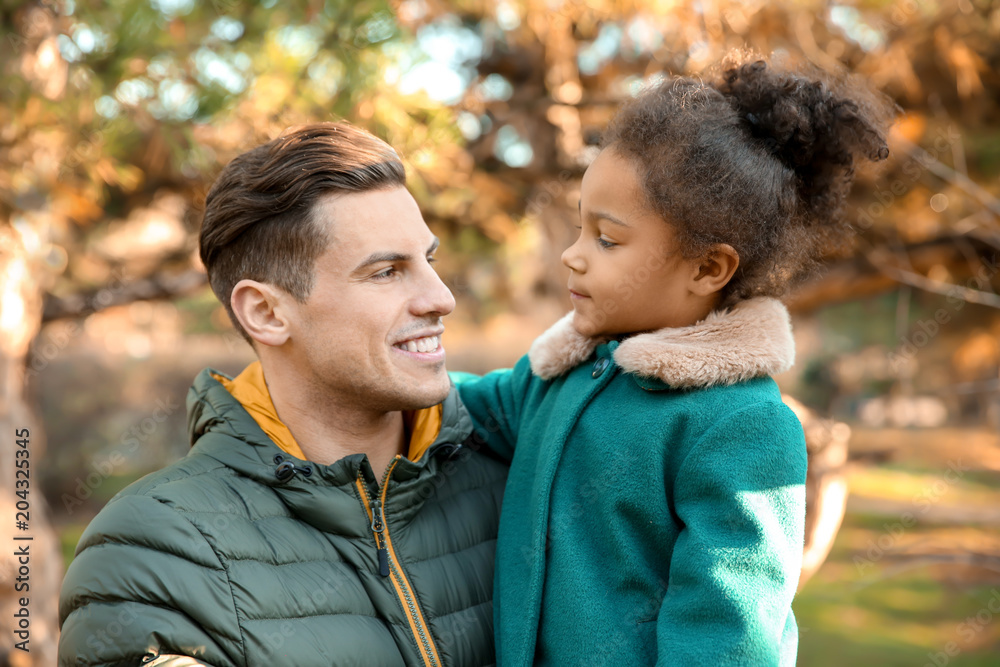 Young man and little African-American girl outdoors on sunny day. Child adoption Young man and little African-American girl outdoors on sunny day. Child adoption