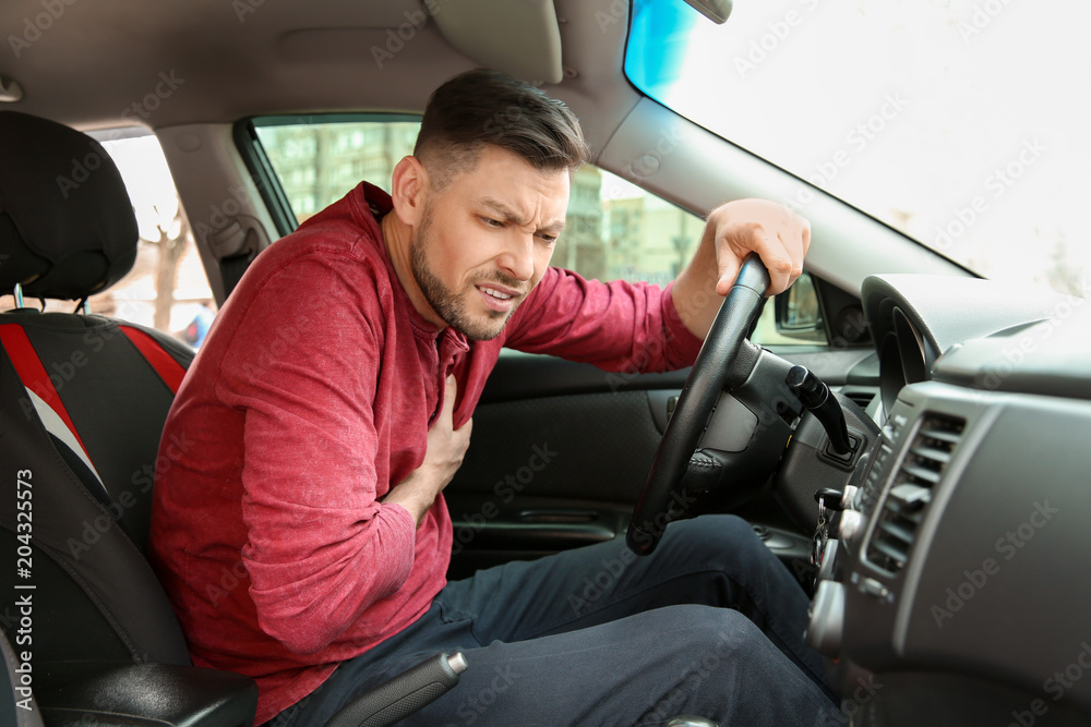 Mature man suffering from heart attack in car Mature man suffering from heart attack in car