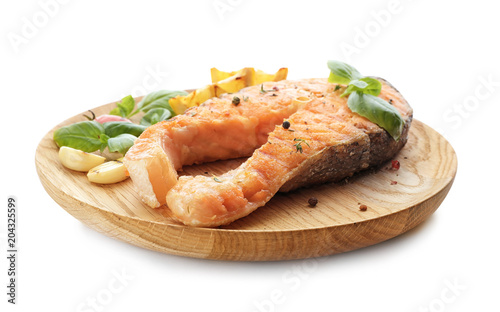 Plate with tasty salmon steak on white background