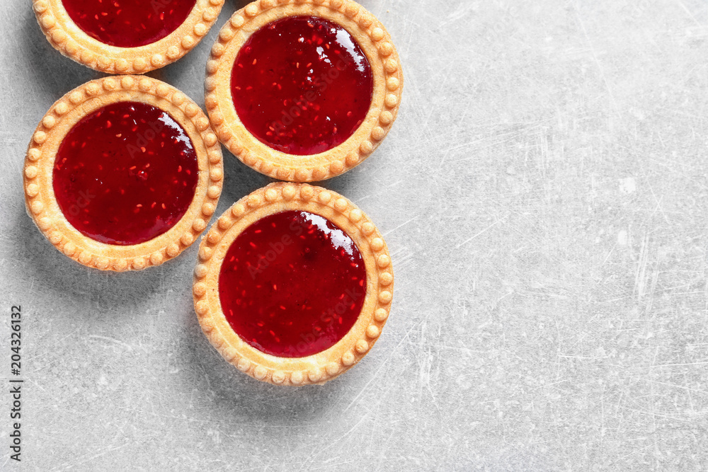 Tasty tartlets with jam on grey background Tasty tartlets with jam on grey background