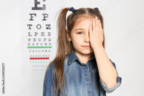 Obraz na plátně Cute little girl visiting ophthalmologist