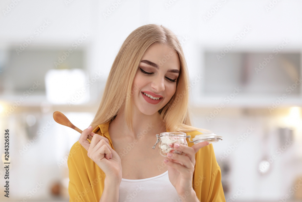 Young woman with yogurt on blurred background Young woman with yogurt on blurred background