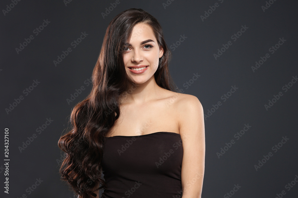 Portrait of beautiful model with gorgeous curly hair on black background