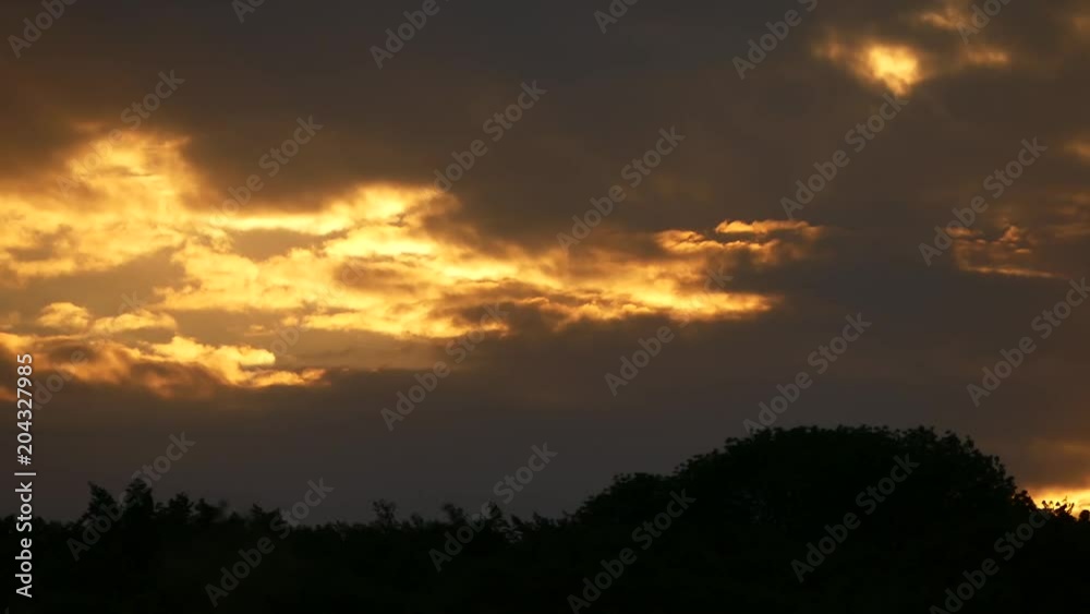 The clouds quickly move against the background of an orange beautiful sunset. The clouds quickly move against the background of an orange beautiful sunset.