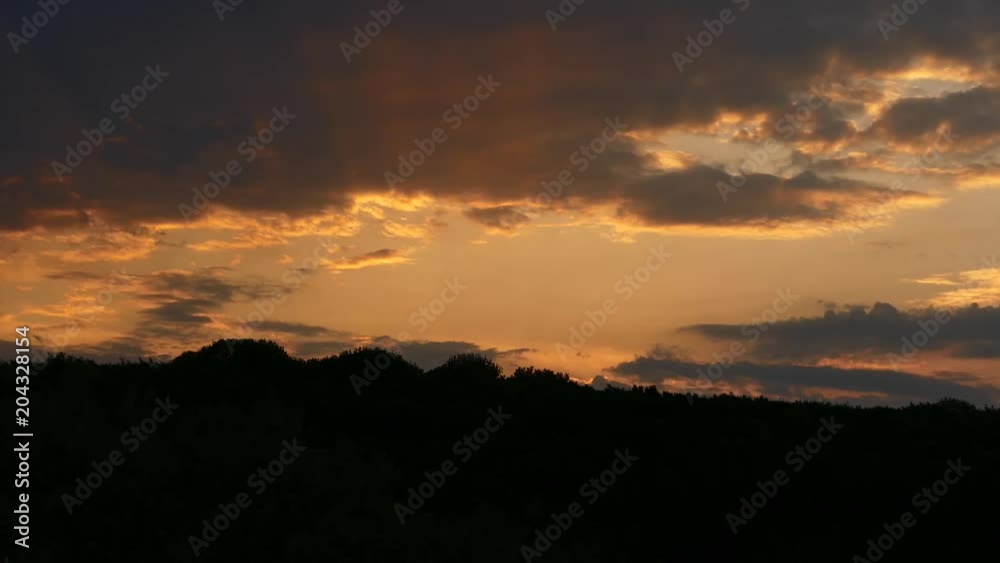The clouds quickly move against the background of an orange beautiful sunset. The clouds quickly move against the background of an orange beautiful sunset.