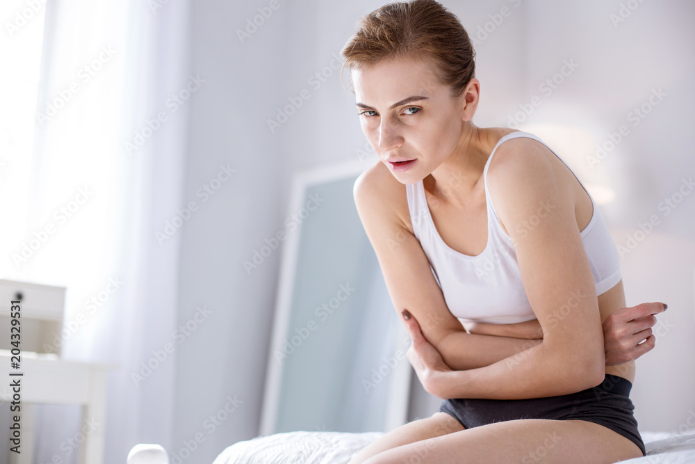 Cheerless young woman suffering from pain Cheerless young woman suffering from pain