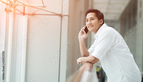 Handsome young man using his mobile phone in the workplace.