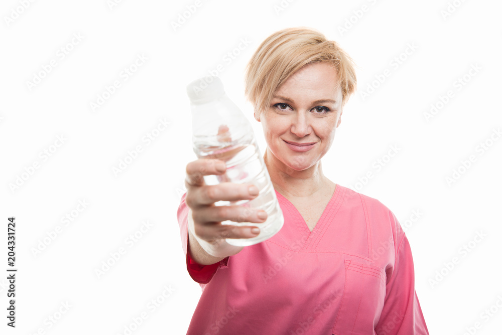 Attractive female doctor wearing scrubs handing water Attractive female doctor wearing scrubs handing water