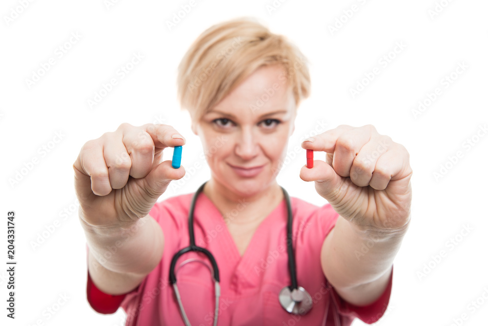 Selective focus of female nurse wearing pink scrubs holding pills Selective focus of female nurse wearing pink scrubs holding pills