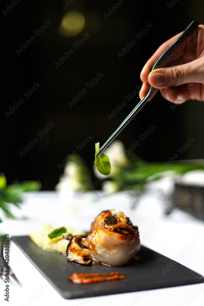 Close up of man's hand garnishing food Close up of man's hand garnishing food