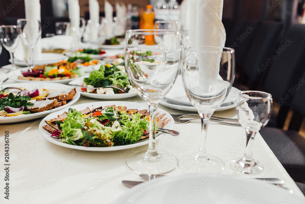 catering table set service with silverware and glass stemware at