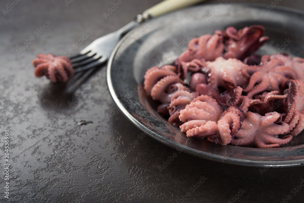 Pickled octopus on old metal plate Pickled octopus on old metal plate