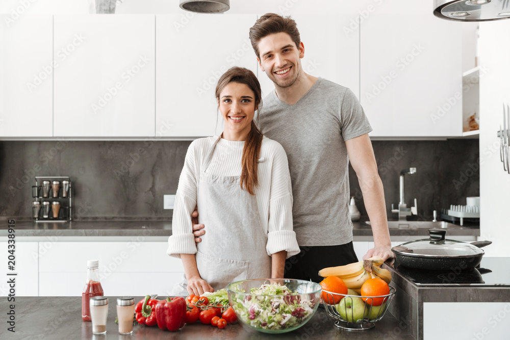Portrait of a happy young couple cooking together Portrait of a happy young couple cooking together