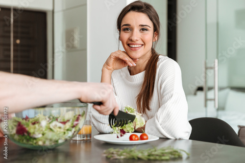 Portrait of a happy young woman having healthy breakfast