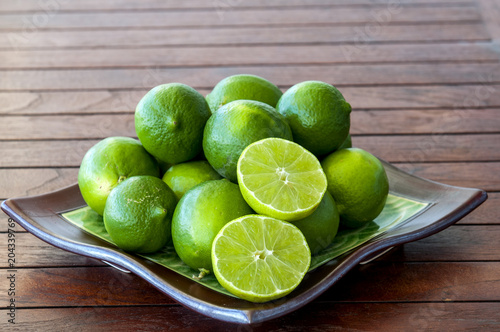 Plate of vibrant green limes with one sliced open