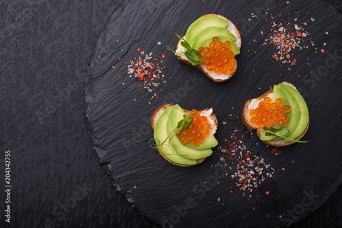 Tasty bruschetta with avocado and caviar