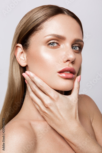 Beauty portrait of model with natural make-up. Fashion shiny highlighter on skin, sexy gloss lips make-up