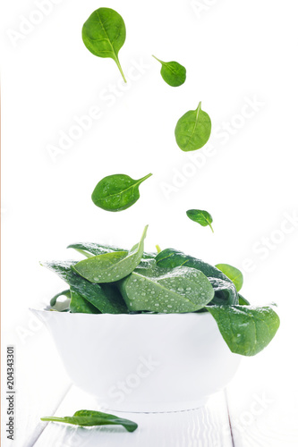 Fresh raw spinach in white bowl