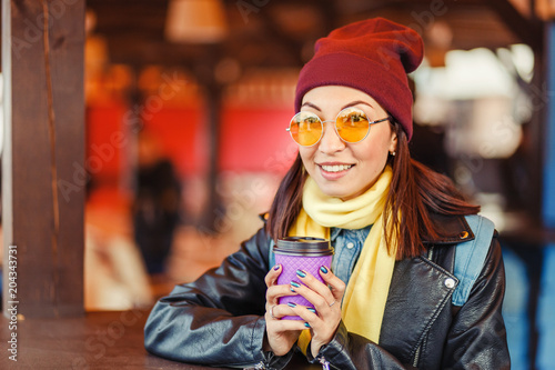 Hipster stylish woman drink takeaway hot coffee at outdoor cafe