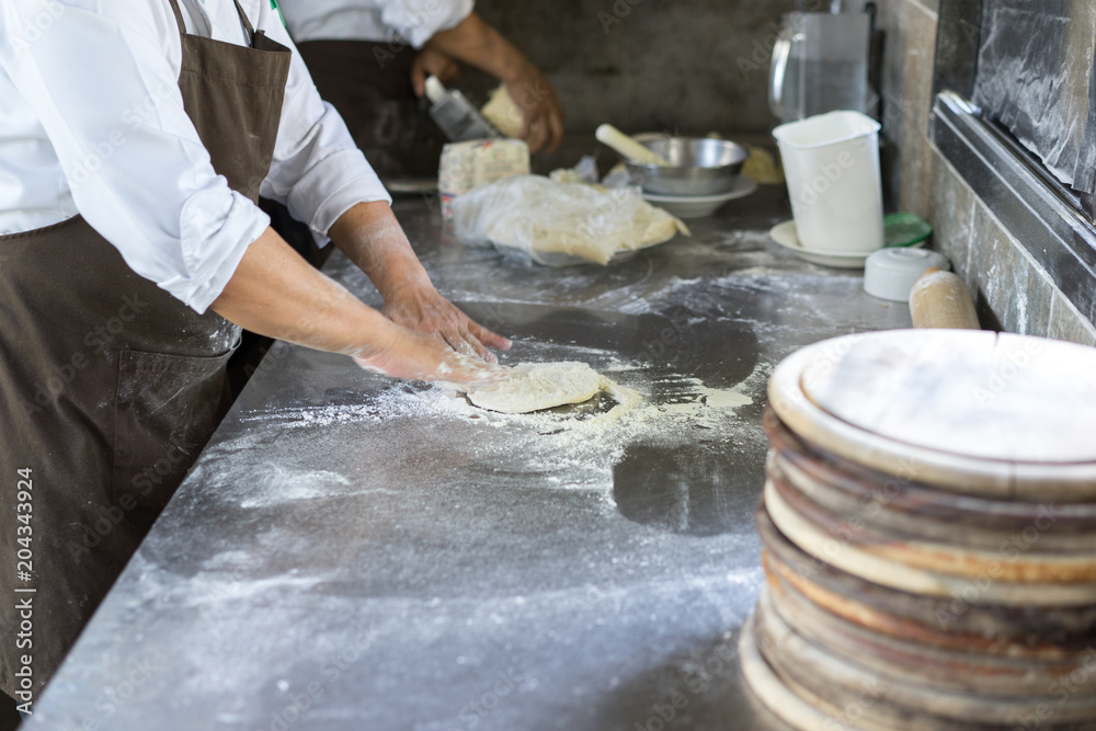 Hands kneading dough for pizza making, chef preparing base for making traditional italian meal. Hands kneading dough for pizza making, chef preparing base for making traditional italian meal.