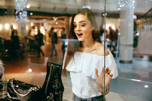 Young Woman Looking Through Shop Window