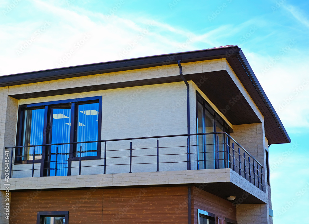 New modern architectural building of the house. large panoramic Windows. Against the blue sky.