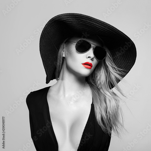 Beautiful young woman in hat and sunglasses